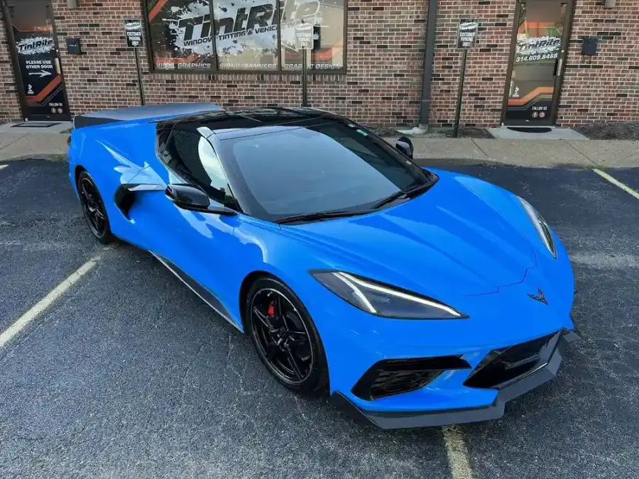 Bright blue Corvette Stingray with freshly tinted side windows in the shop's lot