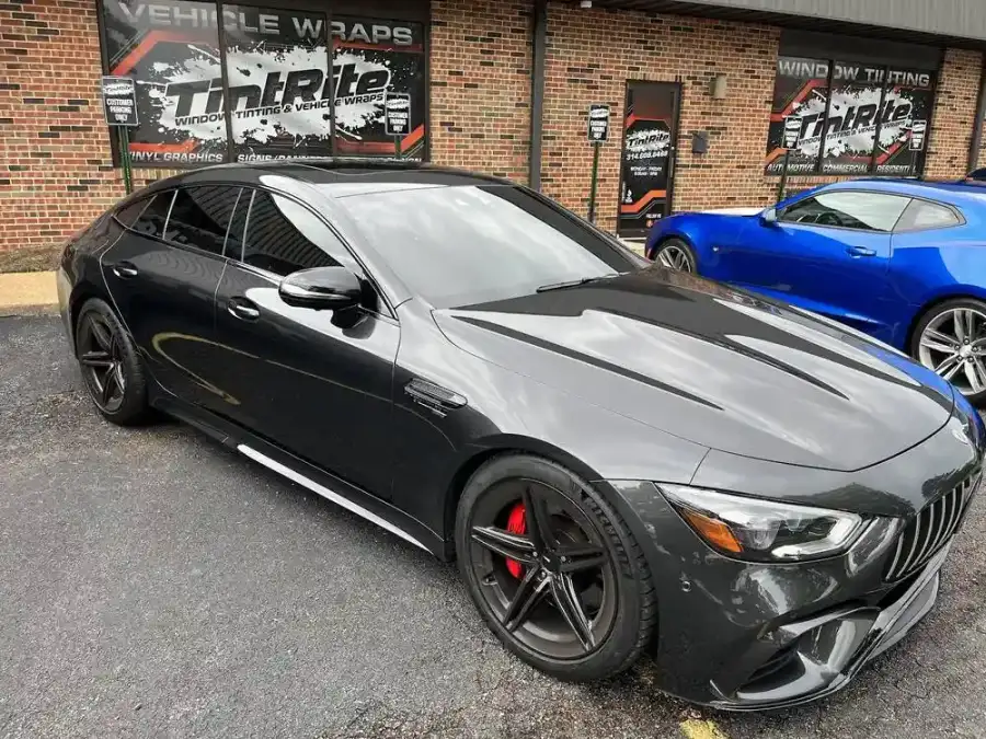 Gray Mercedes-AMG GT four-door with dark window tint, parked outside the shop