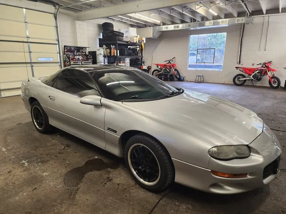Silver Camaro Z28 with tinted windows inside the shop's clean install bay