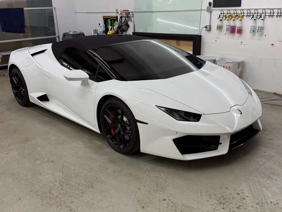 White Lamborghini Huracán with tinted windows inside an install bay
