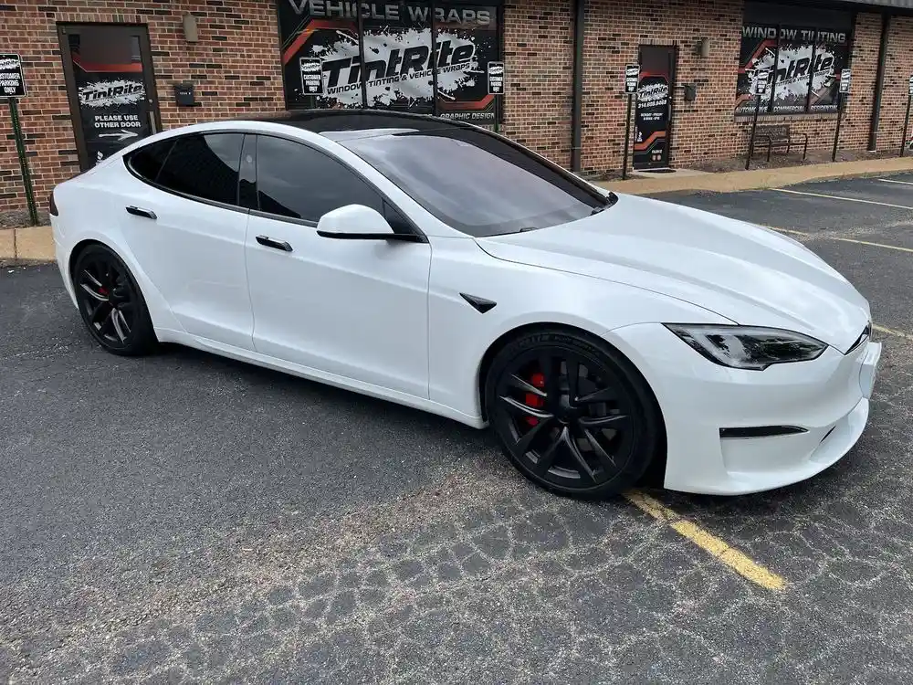 White Tesla Model S with tinted windows parked outside the shop in St. Louis